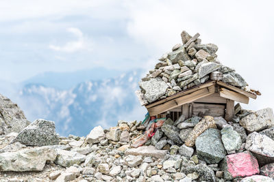 Stack of stones on rock against sky