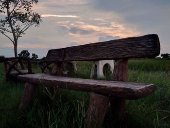 Wooden structure on field against sky during sunset