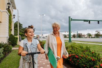 Portrait of happy senior women and granddaughter walking and smiling