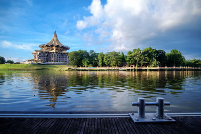 Sarawak state legislative assembly by river against sky