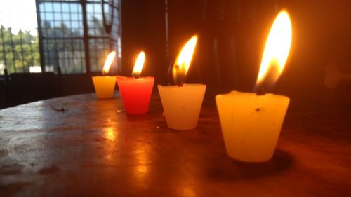 Close-up of illuminated tea light candles at home