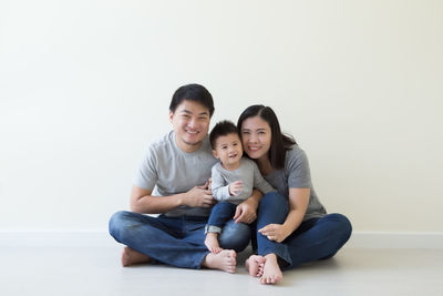 Portrait of smiling women sitting against white background