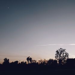 Silhouette trees on landscape against sky