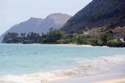 Scenic view of sea and mountains against sky