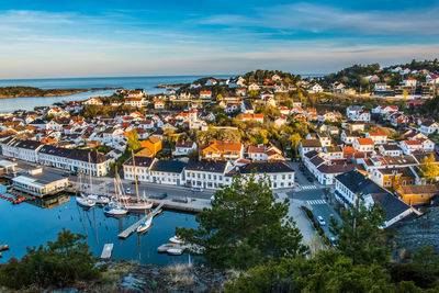 High angle view of townscape by sea against sky