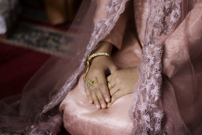 Midsection of bride sitting at home