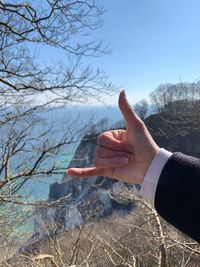 Midsection of man with arms raised against sky