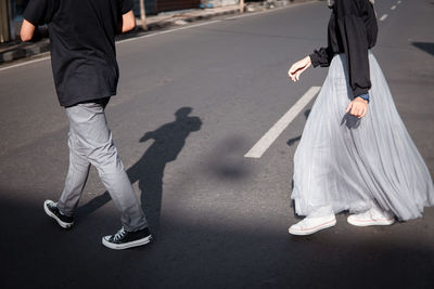 Low section of man walking on road