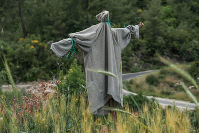 Scarecrow in forest and plants