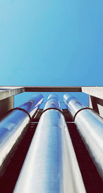 Low angle view of factory against clear blue sky