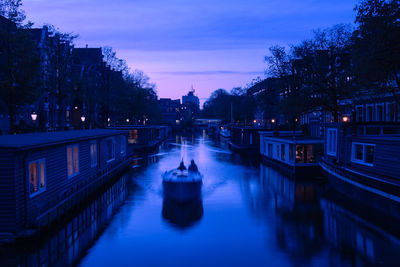 Illuminated bridge over canal in city at night