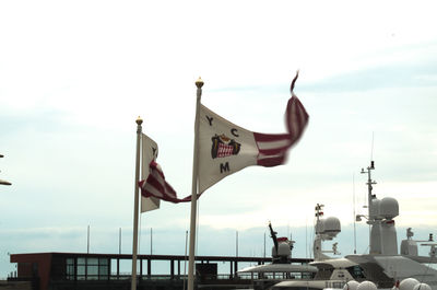 Low angle view of flag against sky in city