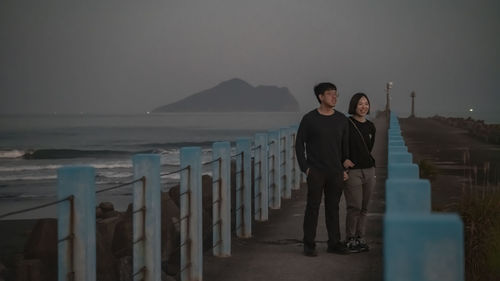 Rear view of woman standing against sea