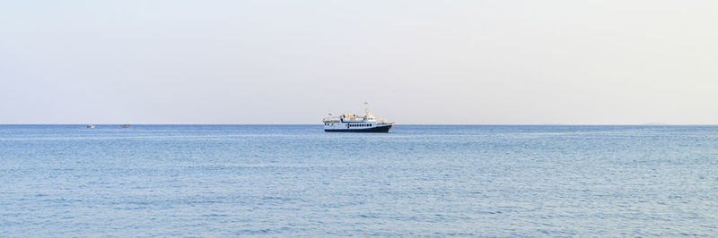 Sailboat sailing on sea against clear sky