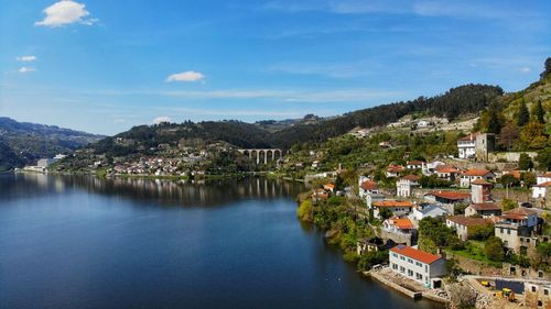 Scenic view of townscape by mountains against sky