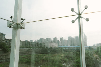 Buildings against sky seen through glass window