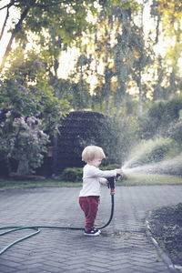 Rear view of boy standing in water