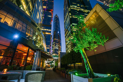 Low angle view of illuminated buildings in city at night