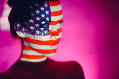 Close-up of multi colored flags against pink wall