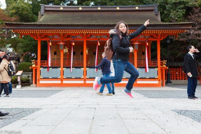 Full length of woman jumping while walking in city