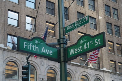 Low angle view of road sign against building