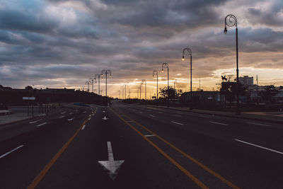 Cars on road against sky during sunset