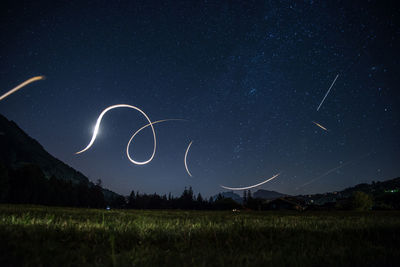 Scenic view of light trails in sky at night