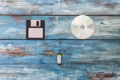 Close-up of floppy disc with cd and usb stick on wooden table