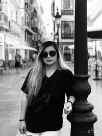 Portrait of young woman standing in city