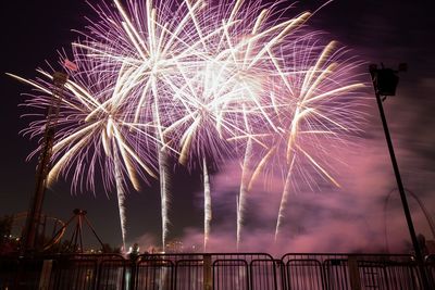 Low angle view of firework display against sky at night