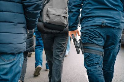 Riot police with gun marching with protestors at anti-war rally