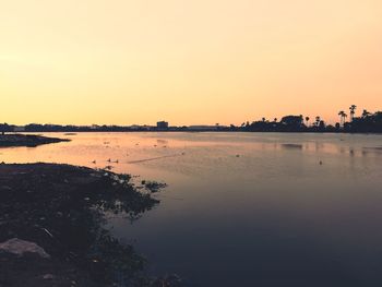 Scenic view of lake against clear sky during sunset