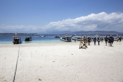 Group of people on beach against sky