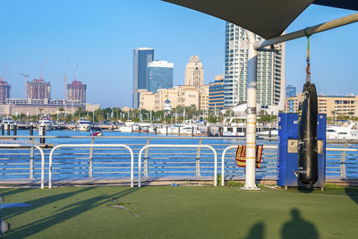 Outdoor health club in front of lake with buildings in background