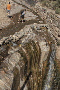 High angle view of man climbing on rock