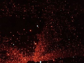 Firework display against sky at night