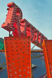 Low angle view of red metal structure against sky