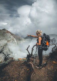 Full length of woman standing on mountain against sky