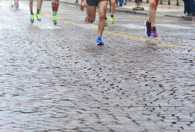 Low section of people running on wet street