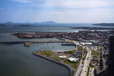 High angle view of city by sea against sky