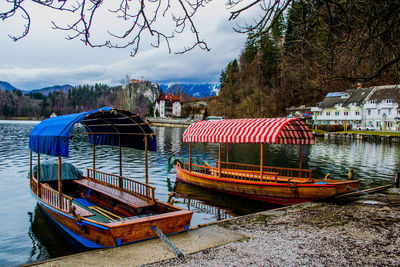 Boats moored in river against sky