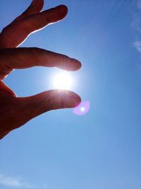 Low angle view of sun shining through clouds