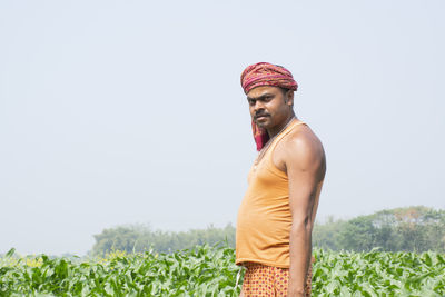 Portrait of smiling indian farmer at corn field looking at camera