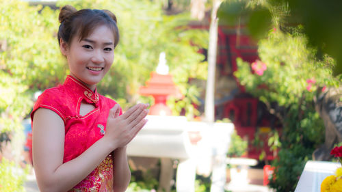 Portrait of smiling young woman standing outdoors