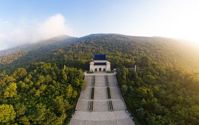 Built structure by plants on mountain against sky