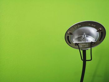 Close-up of electric lamp against green background