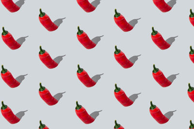 Seamless red chili peppers pattern on light grey background. isometric layout.