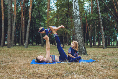 Family yoga. mother and baby doing yoga exercises for beginners outdoors. family doing yoga