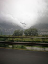 Scenic view of road by trees against sky