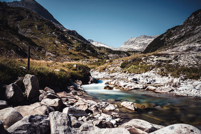 Scenic view of lake by mountains against clear sky